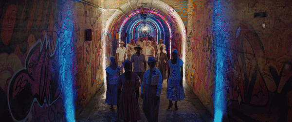 A GIF of a woman walking and looking behind her, then people forming a line