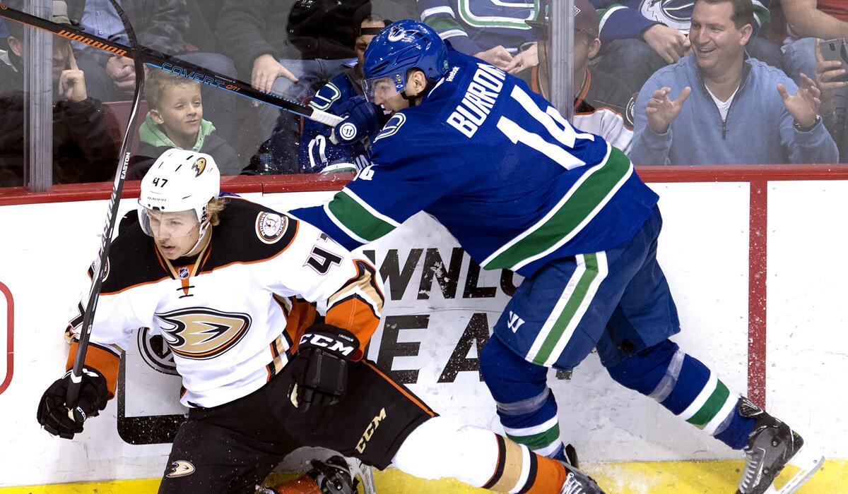 Vancouver left wing Alex Burrows fights for control of the puck with Ducks defenseman Hampus Lindholm during the Ducks' 2-1 loss to the Canucks on Monday.