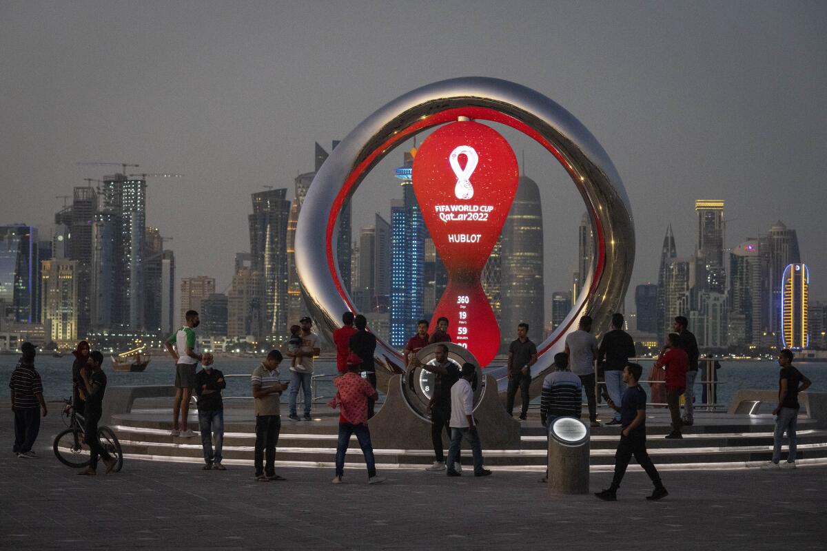 People gather around the official countdown clock for the 2022 World Cup in Doha, Qatar, in November 2021.