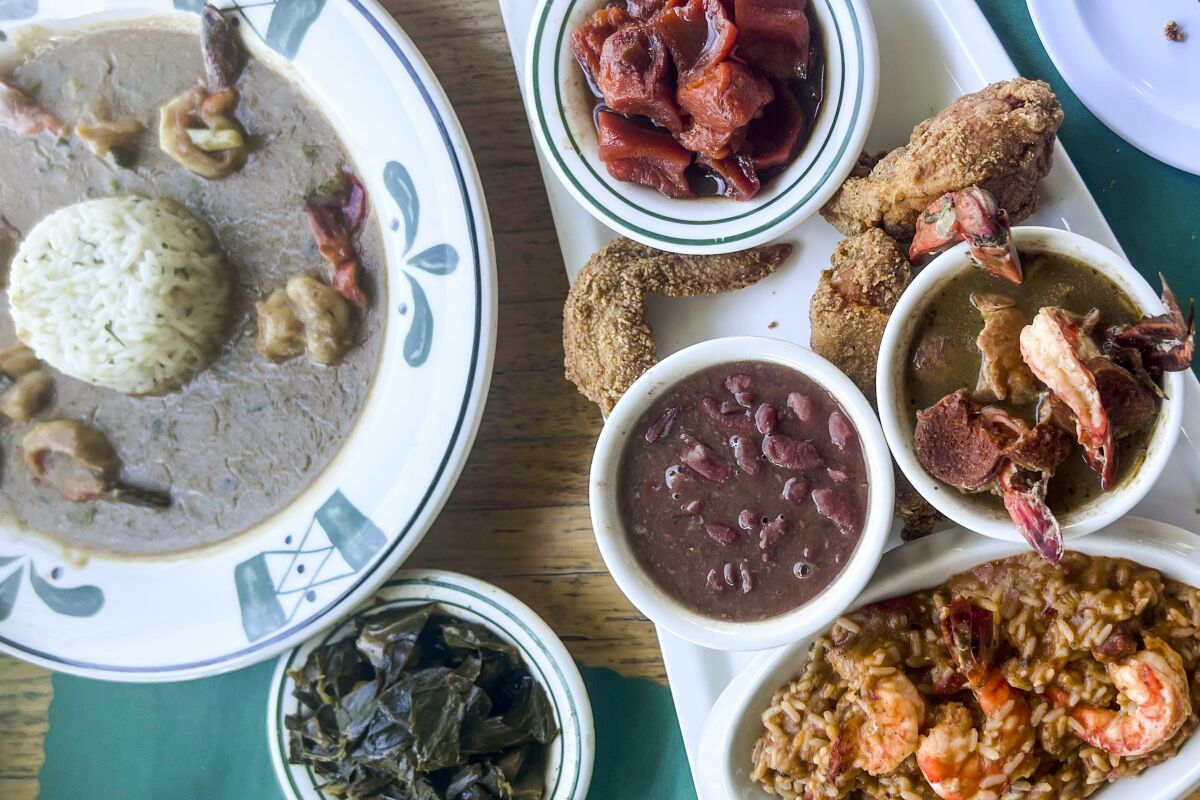 Clockwise from top: Shrimp etoufee, a Creole platter with jambalaya, gumbo, beans, candied yams and fried chicken and a dish of collard greens from La Louisanne.