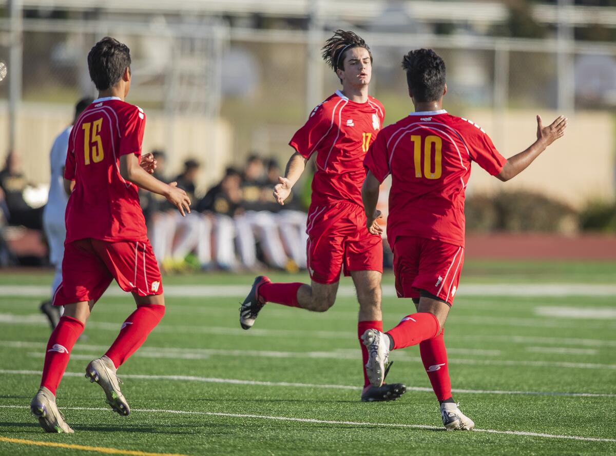 Ocean View's Oswaldo Moran (15), Nathan Santy (17) and Anthony Ruiz (10) celebrate after Ruiz scored a goal in the 17th minute of a Golden West League match against Godinez on Wednesday.