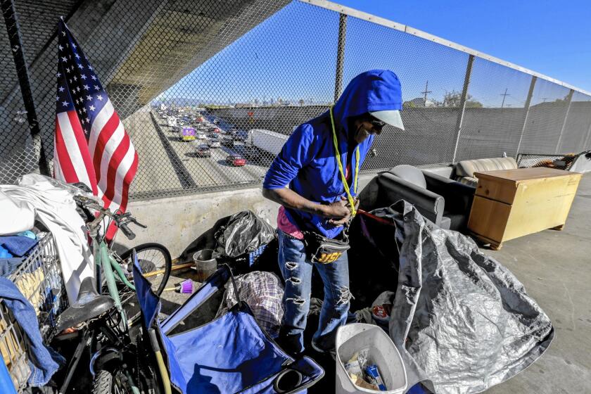 Alice Myles, 60, steps out of her tent, pitched on the 42nd Street bridge over the 110 Freeway. About 26,000 men, women and children are homeless in L.A.