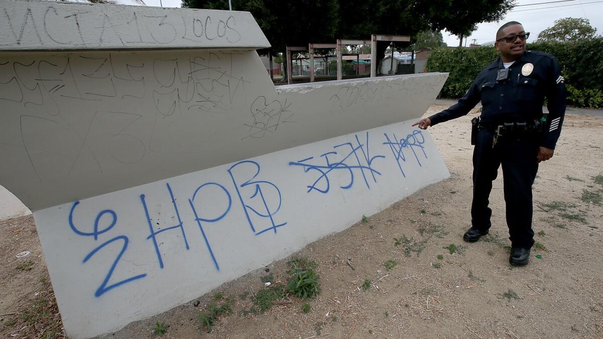 LAPD Senior Lead Officer Gary Verge looks at gang graffiti in Harvard Park in South Los Angeles in this May 2017 file photo.