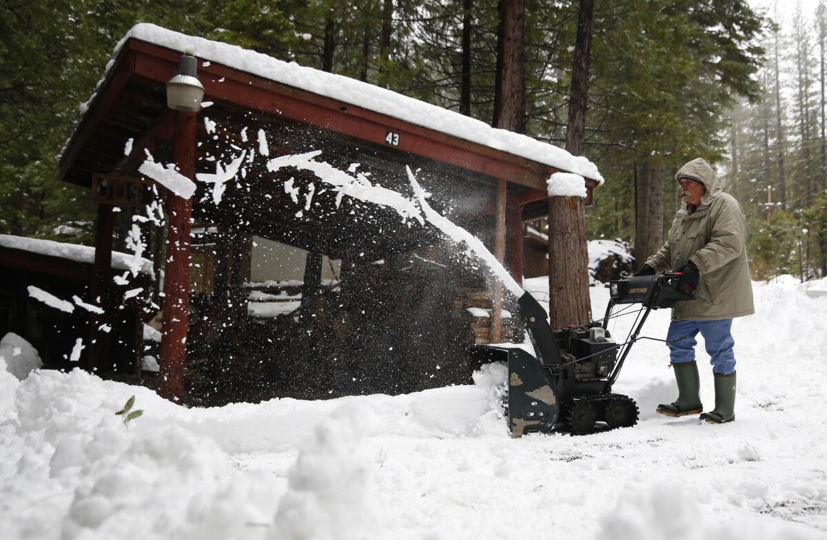 Joe Johnson clears the snow from a neighbor's driveway near Kyburz, Calif., on Tuesday.