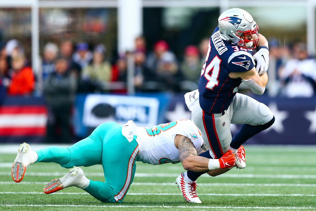 Miami's Calvin Munson tackles New England's Rex Burkhead during the Dolphins' upset victory Sunday at Gillette Stadium.