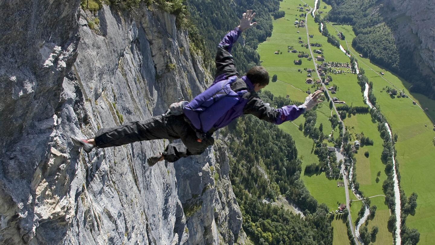 Dean Potter executes a free solo climb and jump with parachute in summer 2008 at Lauterbrunnen in Switzerland.