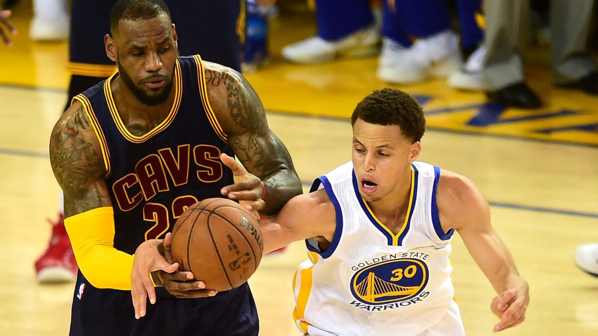 Cavaliers forward LeBron James (23) and Warriors guard Stephen Curry (30) battle for a loose ball during NBA Finals last season.