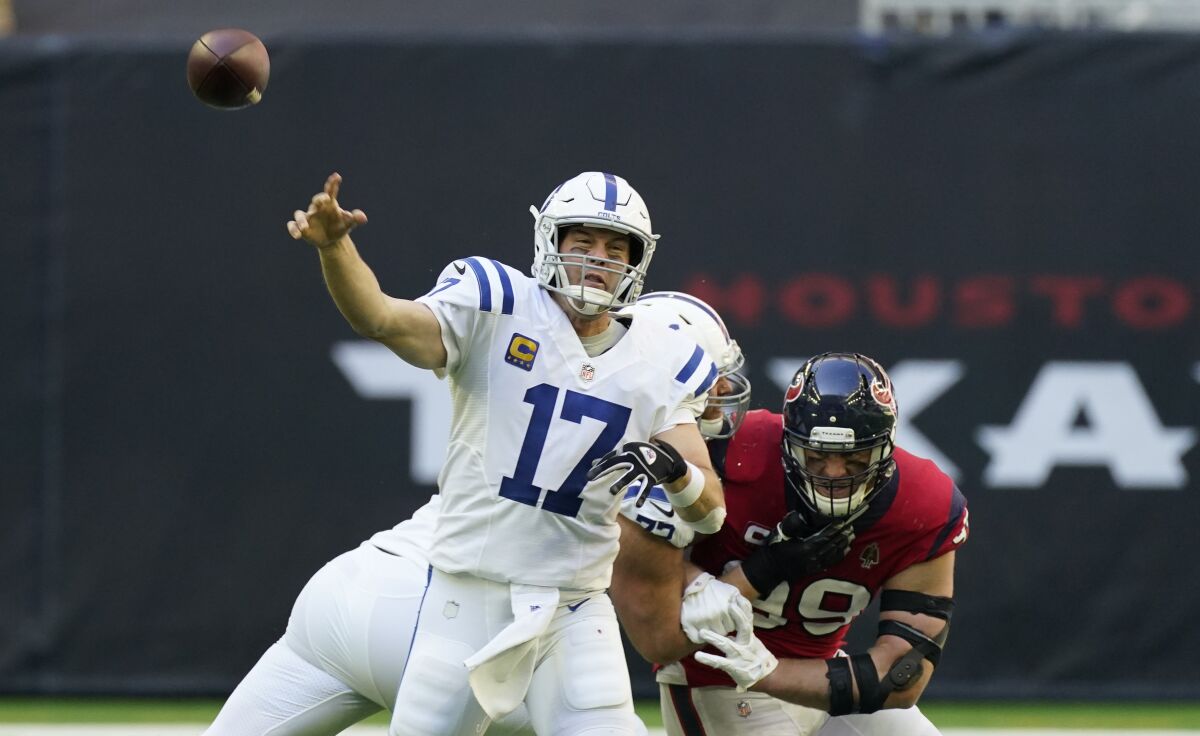 Indianapolis Colts quarterback Philip Rivers throws under pressure from Houston Texans defensive end J.J. Watt.