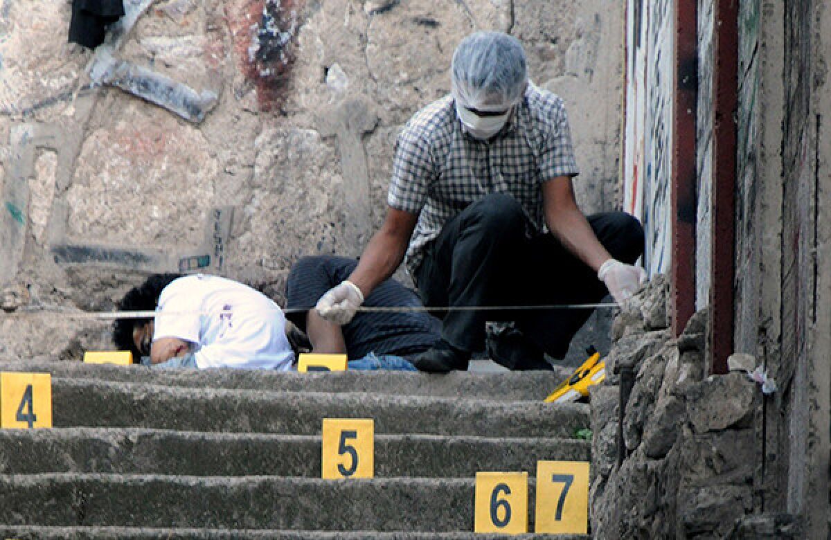 A government worker examines a crime scene in Tegucigalpa, Honduras, where four youngsters were shot to death.