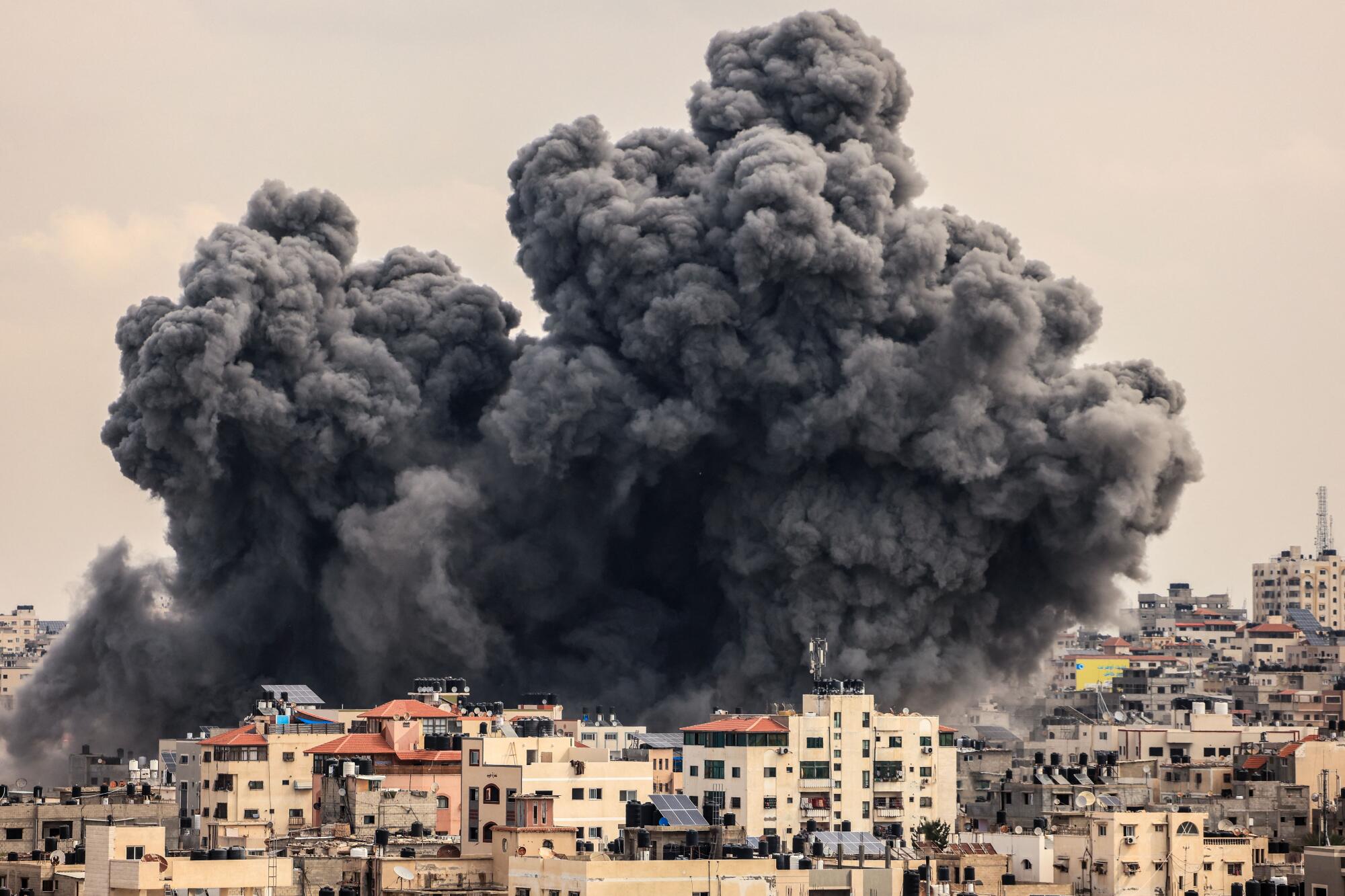 A plume of smoke rises in the sky of Gaza City during an Israeli airstrike.