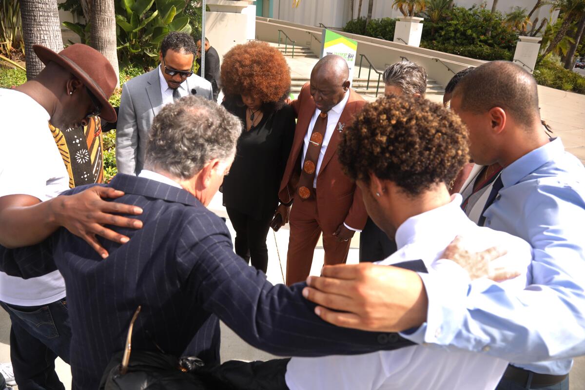 Before their news conference, attorney Ben Crump says a prayer over his legal team and some of the plaintiffs.