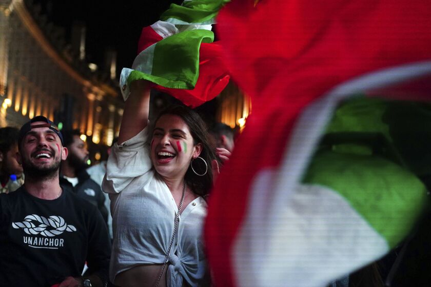 Italy fans celebrate in Piccadilly Circus in central London after their team won the UEFA Euro 2020 Final against England, Sunday July 11, 2021. (Victoria Jones/PA Via AP)