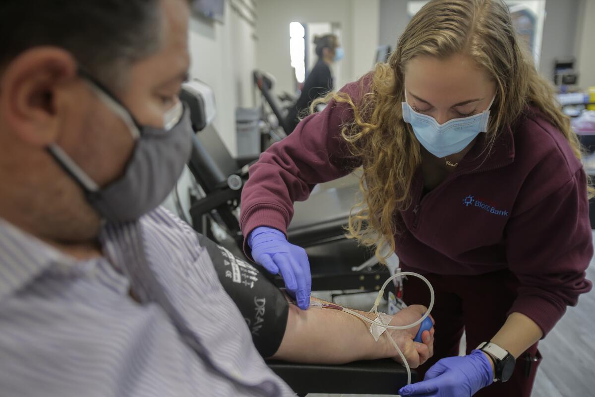 A man gives blood at the Liberty Station Donor Center