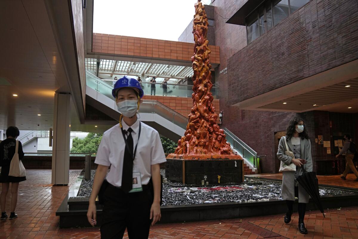 A security guard stands in front of the "Pillar of Shame" statue, a memorial for those killed in the 1989 Tiananmen crackdown, at the University of Hong Kong, Wednesday, Oct. 13, 2021. Danish artist Jens Galschioet is seeking to get back his sculpture in Hong Kong memorializing the victims of China's 1989 Tiananmen Square crackdown as a deadline loomed for its removal Wednesday. (AP Photo/Kin Cheung)