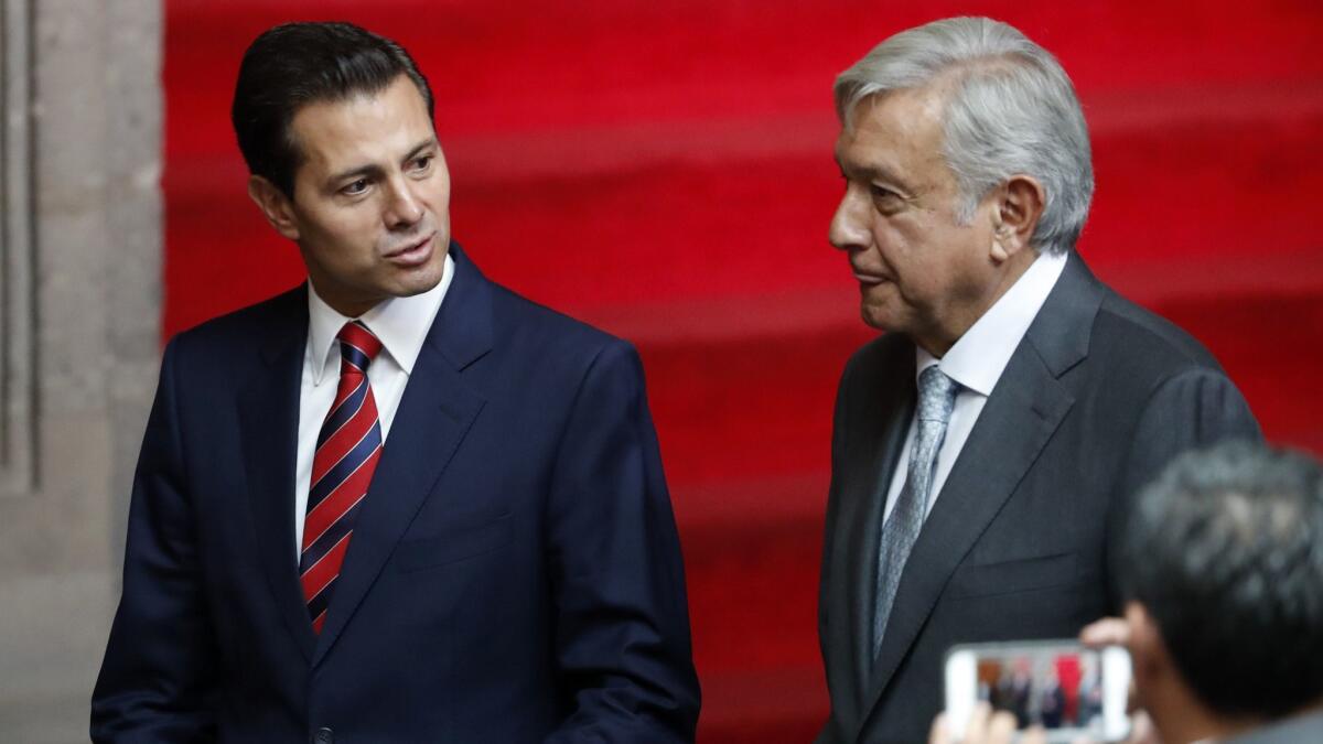 Mexican President Enrique Peña Nieto, left, and President-elect Andres Manuel Lopez Obrador talk at the National Palace in Mexico City, on Aug. 20, 2018.