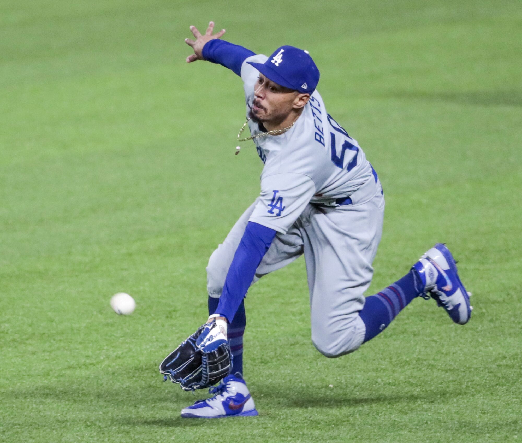 Dodgers right fielder Mookie Betts stretches to make a catch during the third inning of Game 5.