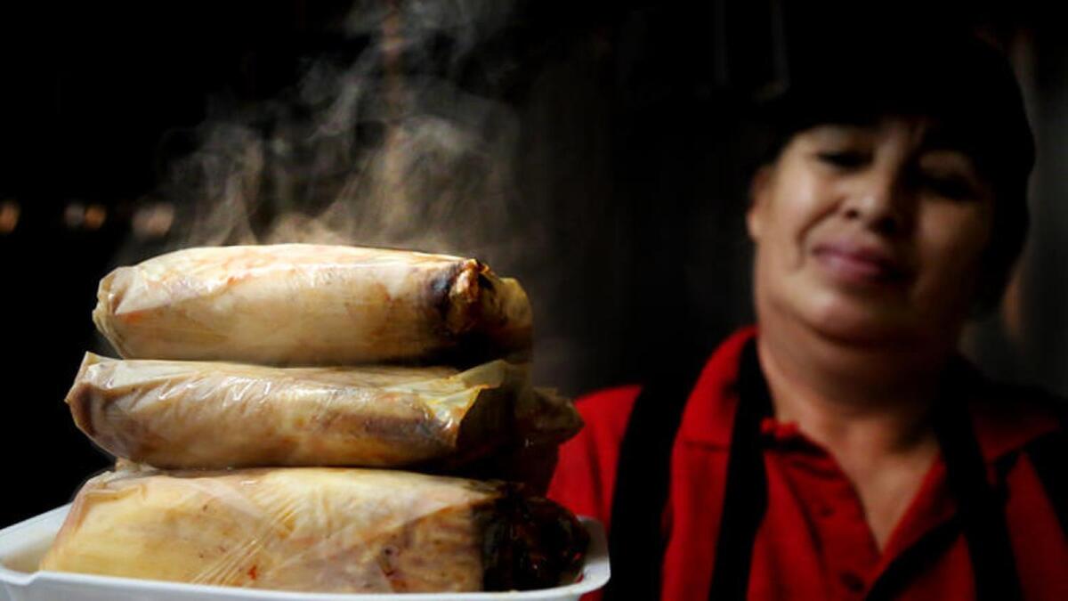 Maria Badajos readies an order of red pork tamales in the kitchen at Juanito's in East Los Angeles.
