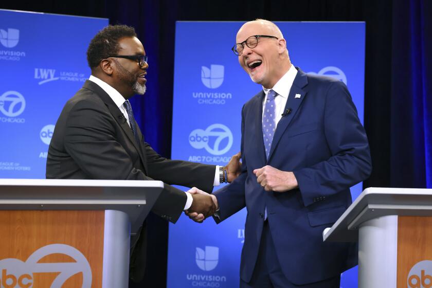 Chicago mayoral candidates Brandon Johnson, left, and Paul Vallas shake hands before the start of a debate at ABC7 studios in downtown Chicago, Thursday, March 16, 2023. (Chris Sweda/Chicago Tribune via AP, Pool)