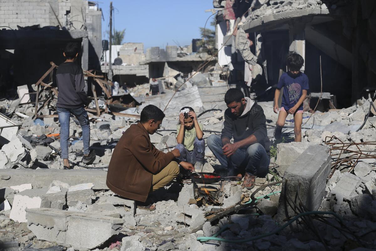 Palestinians cook beside their destroyed homes in the southern Gaza Strip during the temporary cease-fire. 