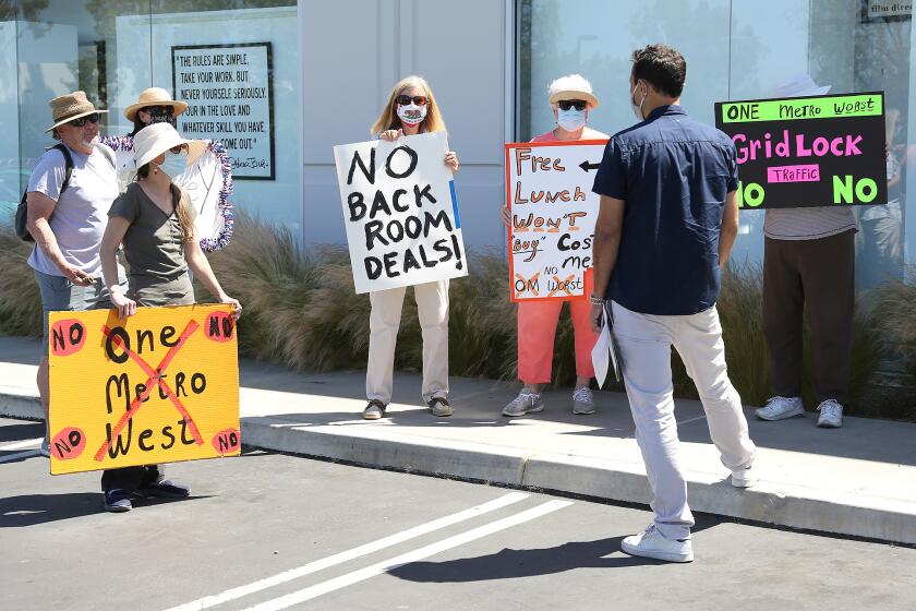 Opponents of One Metro West, a 1,057-unit residential development planned for Costa Mesa, have a discussion with project developer Brent Stoll of Rose Equities during neighborhood block party hosted by the developers at the OC Mix on Friday.