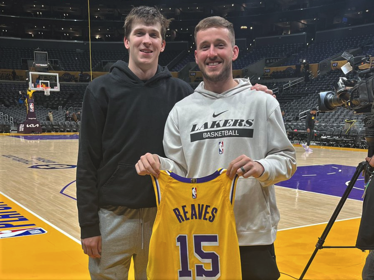 Lakers starter Austin Reaves, left, poses for a photo with his brother Spencer, who is holding Austin's jersey.