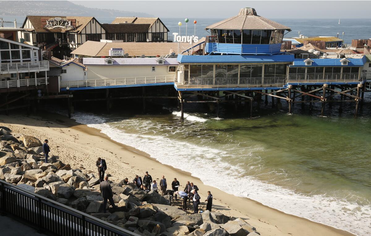 Police continue their investigation near the rocks below the Redondo Beach Pier after a fatal shooting.