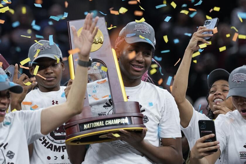 South Carolina's Aliyah Boston holds up the trophy after a college basketball game.