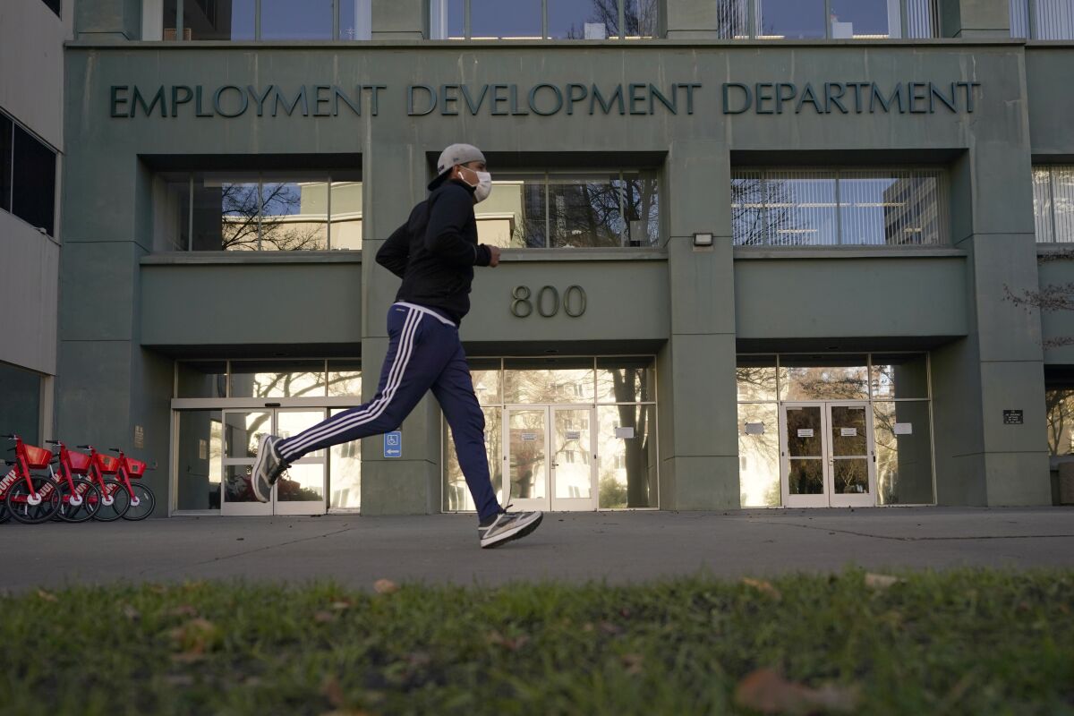 A man jogs in front of the Employment Development Department building