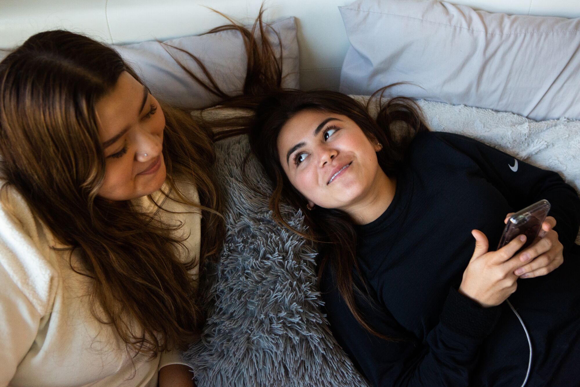 Samantha Zuniga and Dalia Hurtado share a moment while scrolling through social media at Samantha's home March 18, 2020.