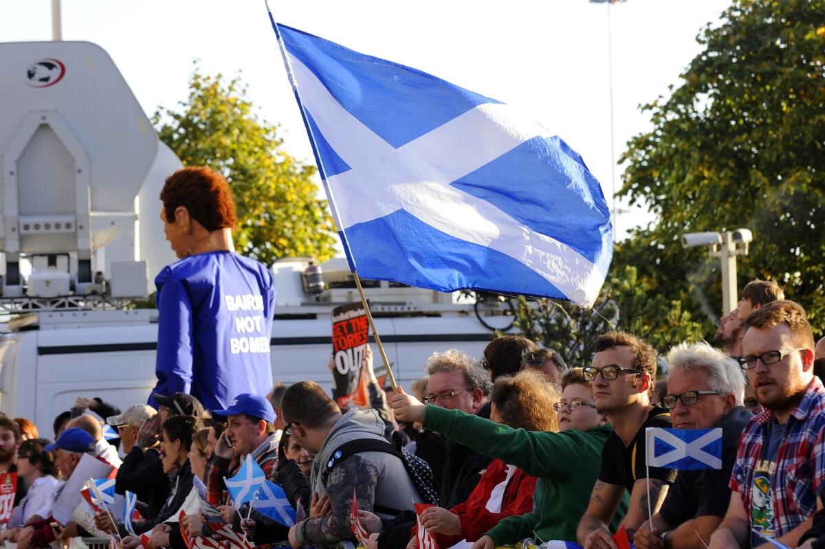 Protesters in Glasgow hold Scottish Saltire flags outside the venue where British Prime Minister David Cameron addressed the Confederation of British Industry Scotland on Aug. 28, saying that the union between Scotland and England was the "greatest merger in history."