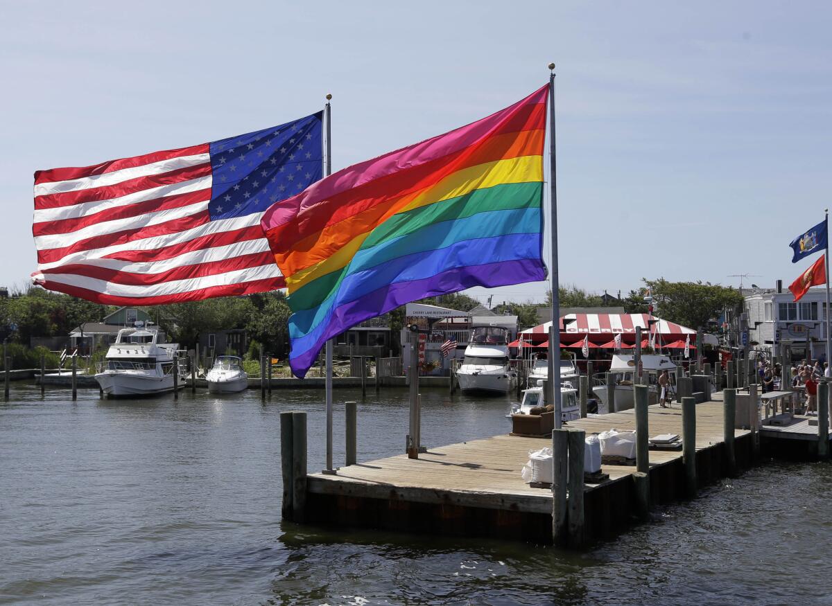 Despite gains in gay rights, people feel federal laws to prohibit discrimination based on sexual orientation are still necessary in certain arenas such as the housing market. Above: An American flag flies next to an LGBT flag in the Fire Island area of Cherry Grove, N.Y., where a gay community has been thriving for decades.