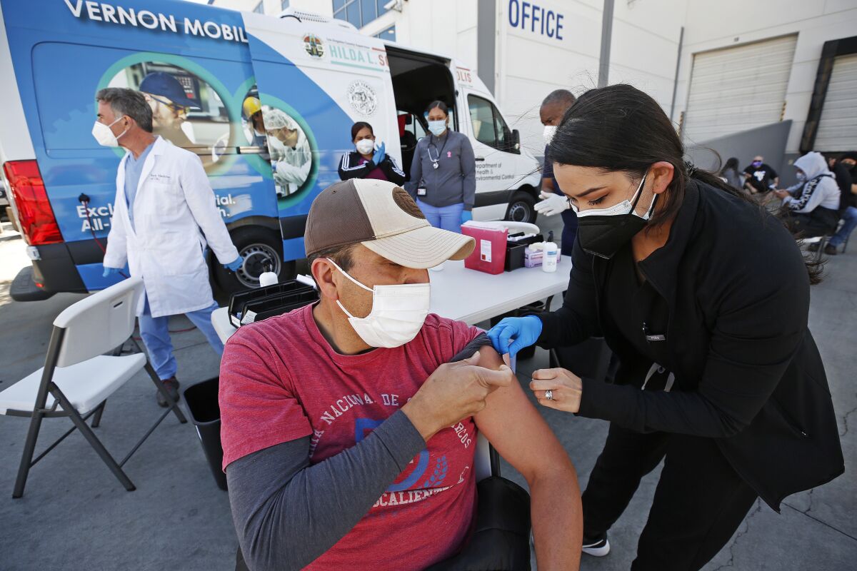 A physician assistant puts a bandage on a man's arm.