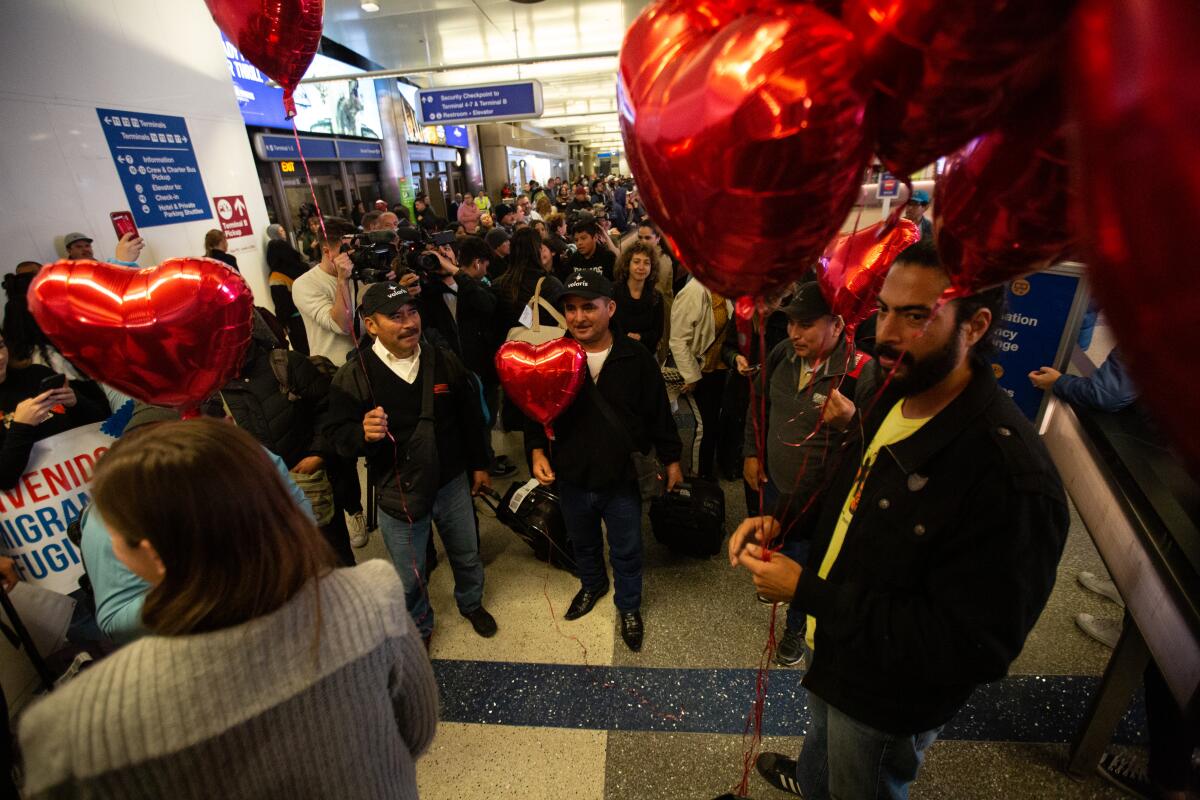 Family members and friends wait at LAX for reunions