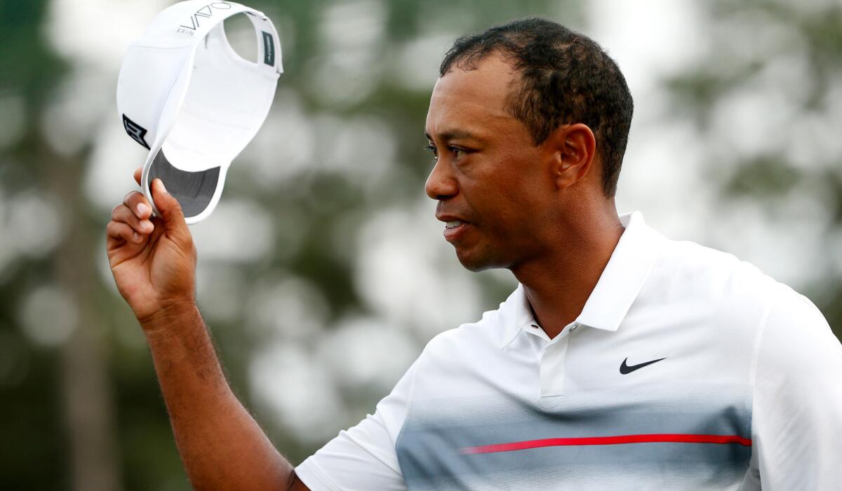 Tiger Woods acknowledges the crowd after completing his first round Thursday at the Masters.