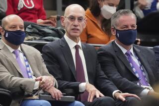 NBA Commissioner Adam Silver, center, looks on in the second half during an NBA basketball game.
