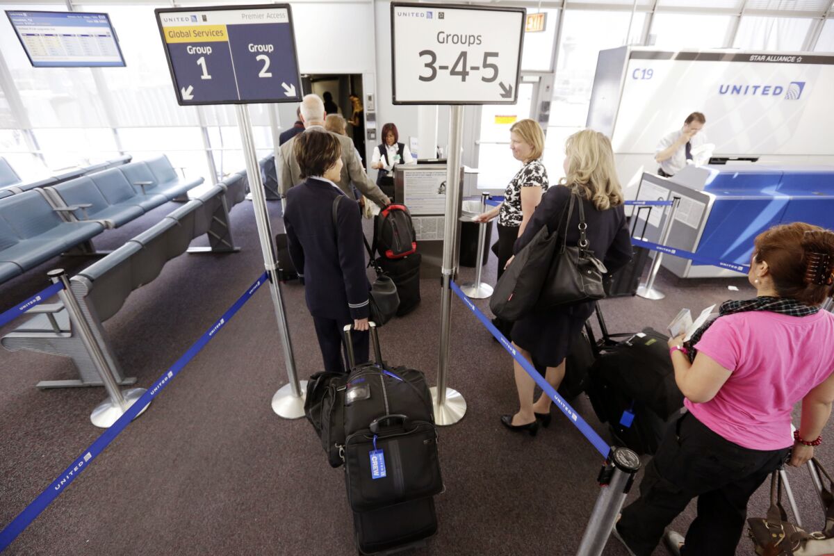 Passengers wait at a United Airlines gate to board a flight at O'Hare International Airport in Chicago. Most of the biggest carriers reported record profits for the first quarter of the year.