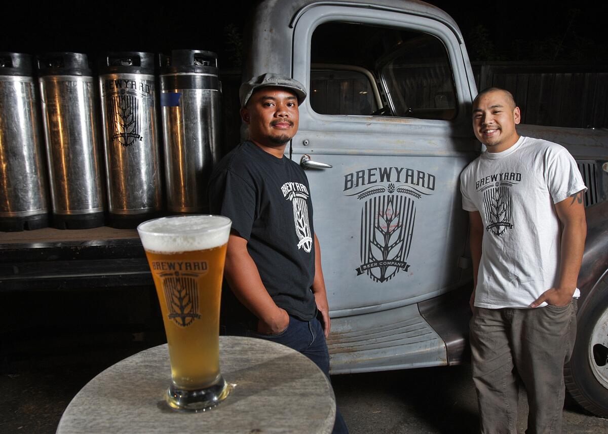 Brewmaster Sherwin Antonio of Mission Hills and partner Kirk Nishikawa of West Los Angeles with the beginnings of a brewery, including a 1930s-era delivery truck, tanks, a freshly poured lychee saizon beer, and a logo in Mission Hills on Wednesday, October 15, 2014. The brewery will be opening in Glendale, they hope, in spring.