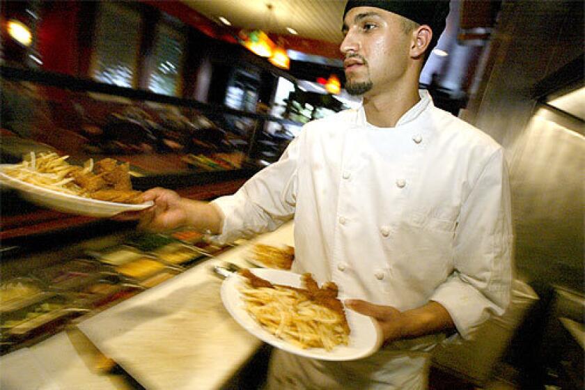 CULINARY SALVATION: Chef Rigo Salas dishes up a couple of chicken-and-fries dinners at Lot 1224, the restaurant inside the Loews Beverly Hills Hotel. His passion for cooking is what saved him from a life as a gang member -- a life he found he could not sustain.