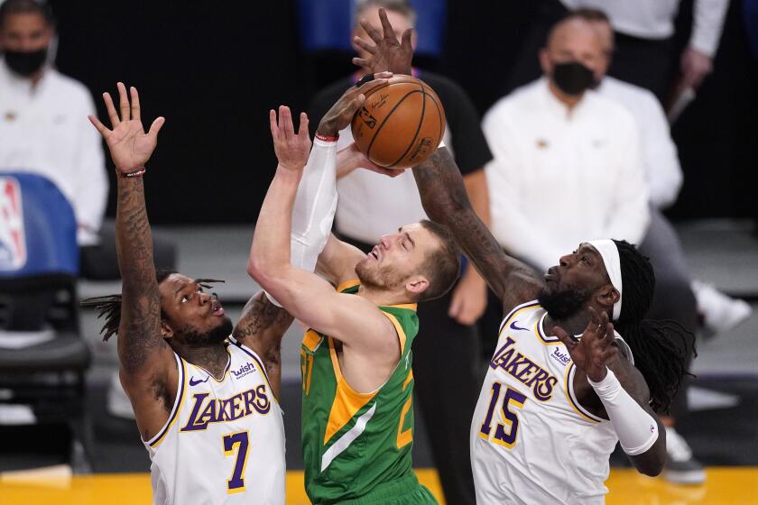 Utah Jazz guard Matt Thomas, center, has his shot blocked by Los Angeles Lakers guard Ben McLemore, left, as center Montrezl Harrell helps defend during the first half of an NBA basketball game Saturday, April 17, 2021, in Los Angeles. (AP Photo/Mark J. Terrill)