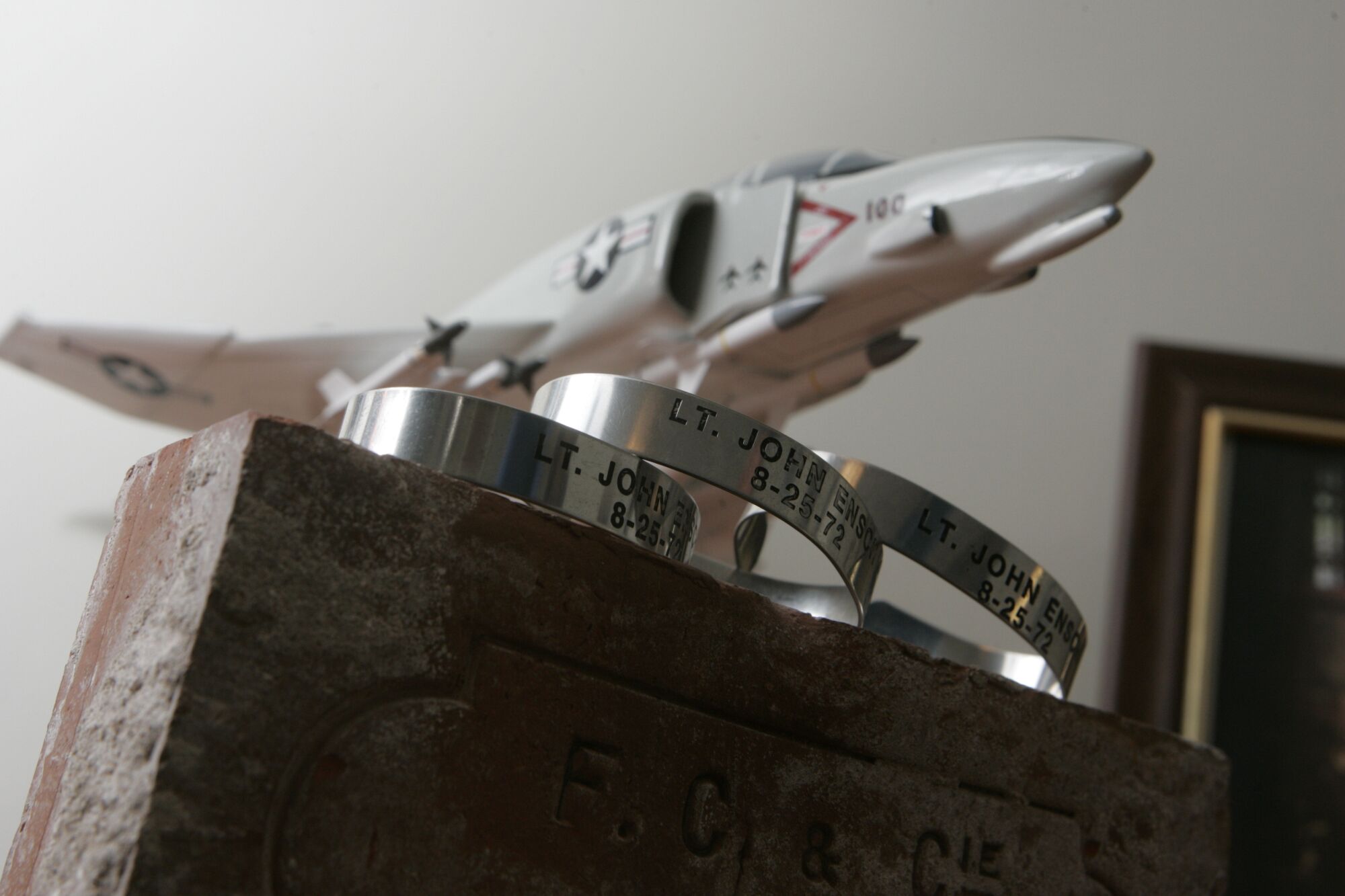 Two metal POW bracelets with Jack Ensch's name engraved on them