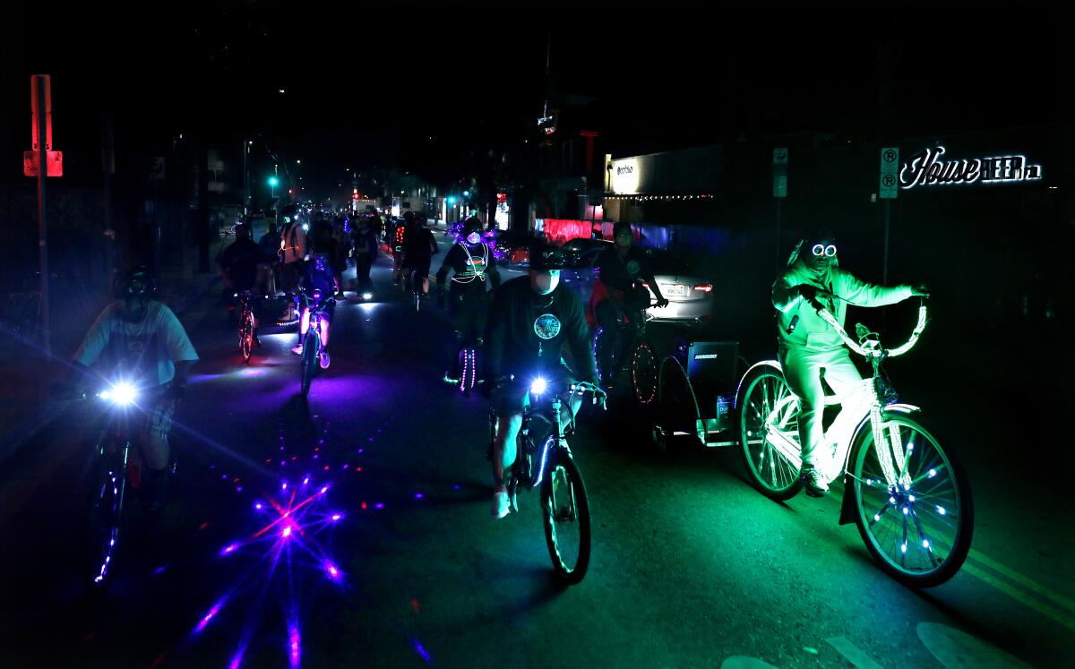 Some cyclists in the Venice Electric Light Parade have devices that project light and shapes on the pavement as they ride.