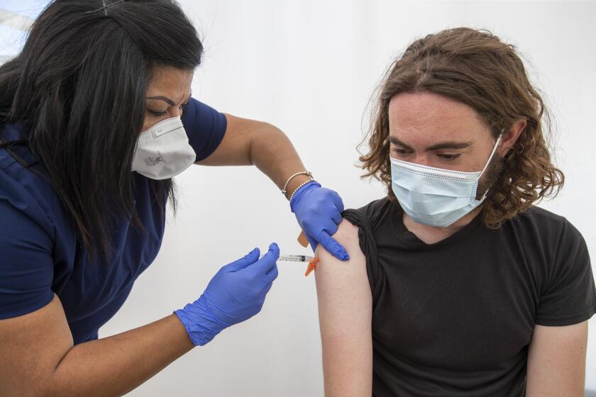 Los Angeles, CA - April 15: Nurse Andrea Delacueva, left, gives a COVID-19 vaccination to Matt Block, 34, of Culver City, at Kedren Health on Thursday, April 15, 2021 in Los Angeles, CA. Award-winning television producer, Marti Noxon, who's a big fan of Kedren Vaccines, sent an In-N-Out truck to feed 200+ volunteers who help make this vaccine program such a huge success and she did so on the day that vaccines are being made available to all people 16+ in Los Angeles. (Allen J. Schaben / Los Angeles Times)