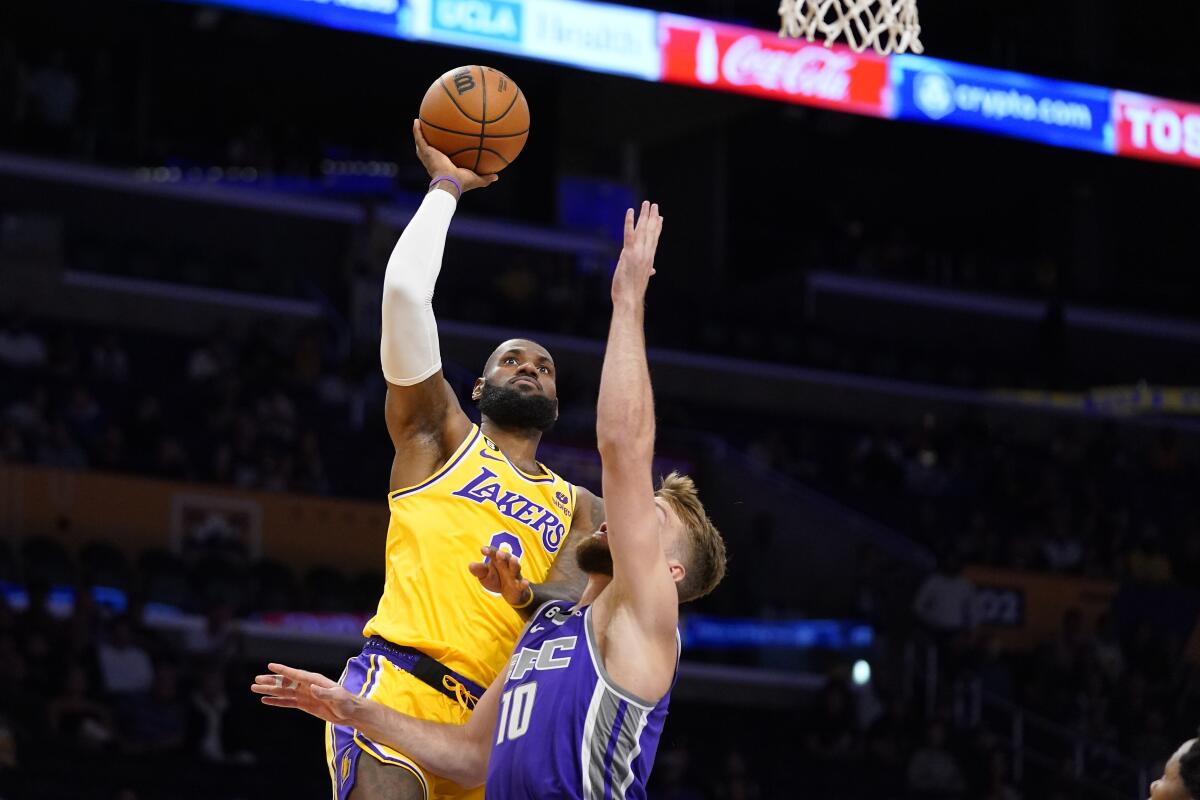 Lakers star LeBron James shoots over Sacramento Kings forward Domantas Sabonis during the first half Monday.