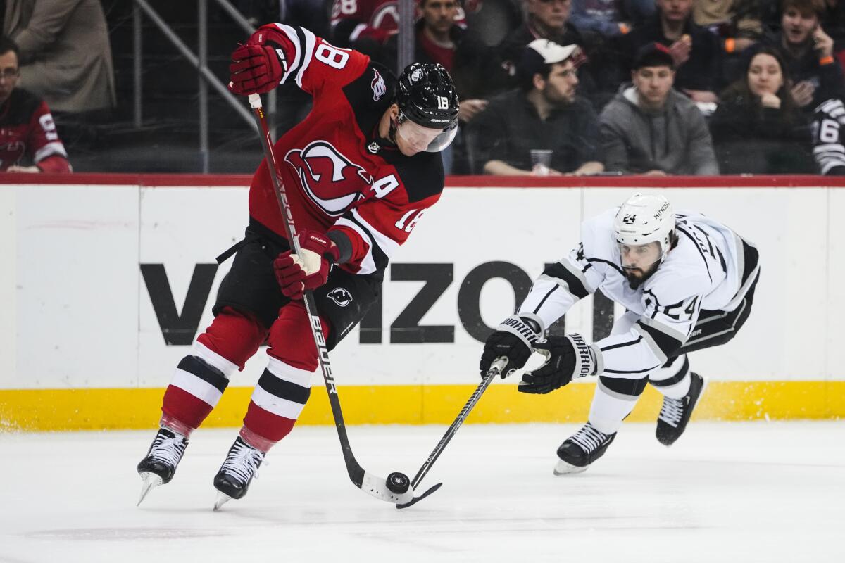 New Jersey Devils' Ondrej Palat fights for control of the puck with Kings' Phillip Danault.