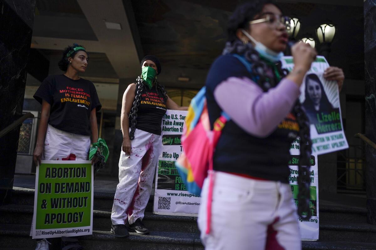 Defensoras del derecho al aborto sostienen letreros durante una protesta en apoyo a Lizelle Herrera 