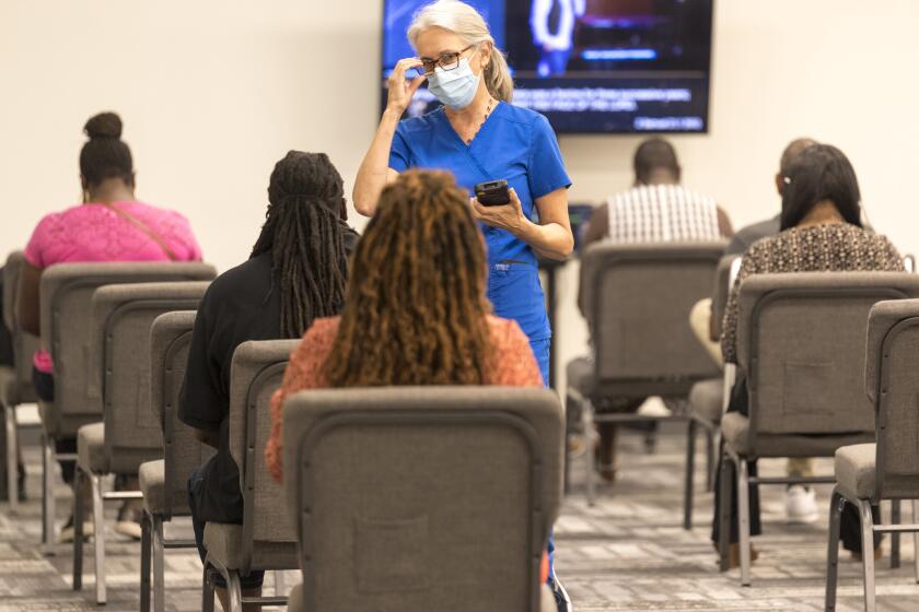In this photo provided by Impact Church, people wait for a COVID-19 vaccination at an event held by Impact Church, Aug. 8, 2021, in Jacksonville, Fla. The church has lost seven members to COVID-19 in the last few weeks, according to Pastor George Davis. (Impact Church via AP)