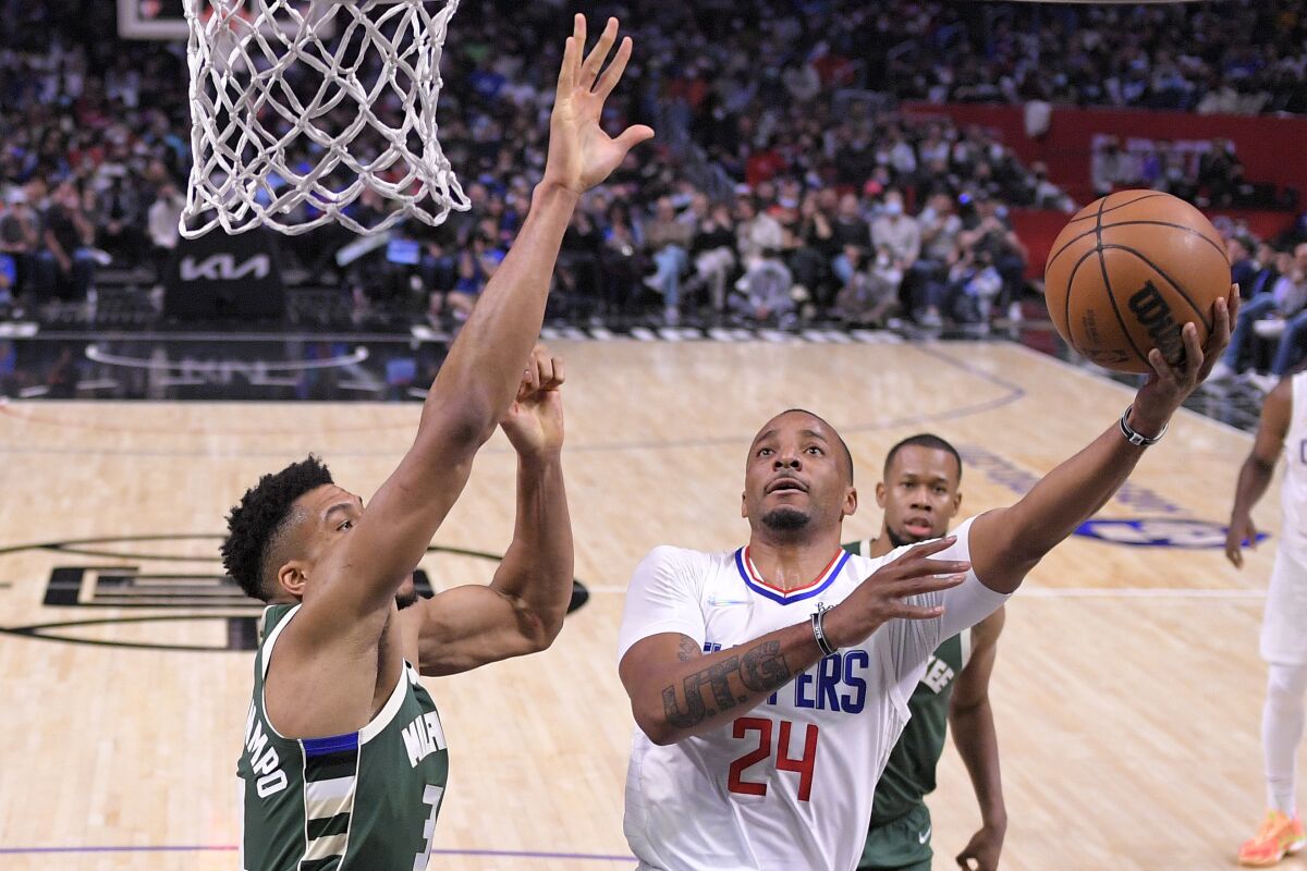 Clippers guard Norman Powell drives for a layup against Bucks forward Giannis Antetokounmpo on Sunday at Crypto.com Arena.