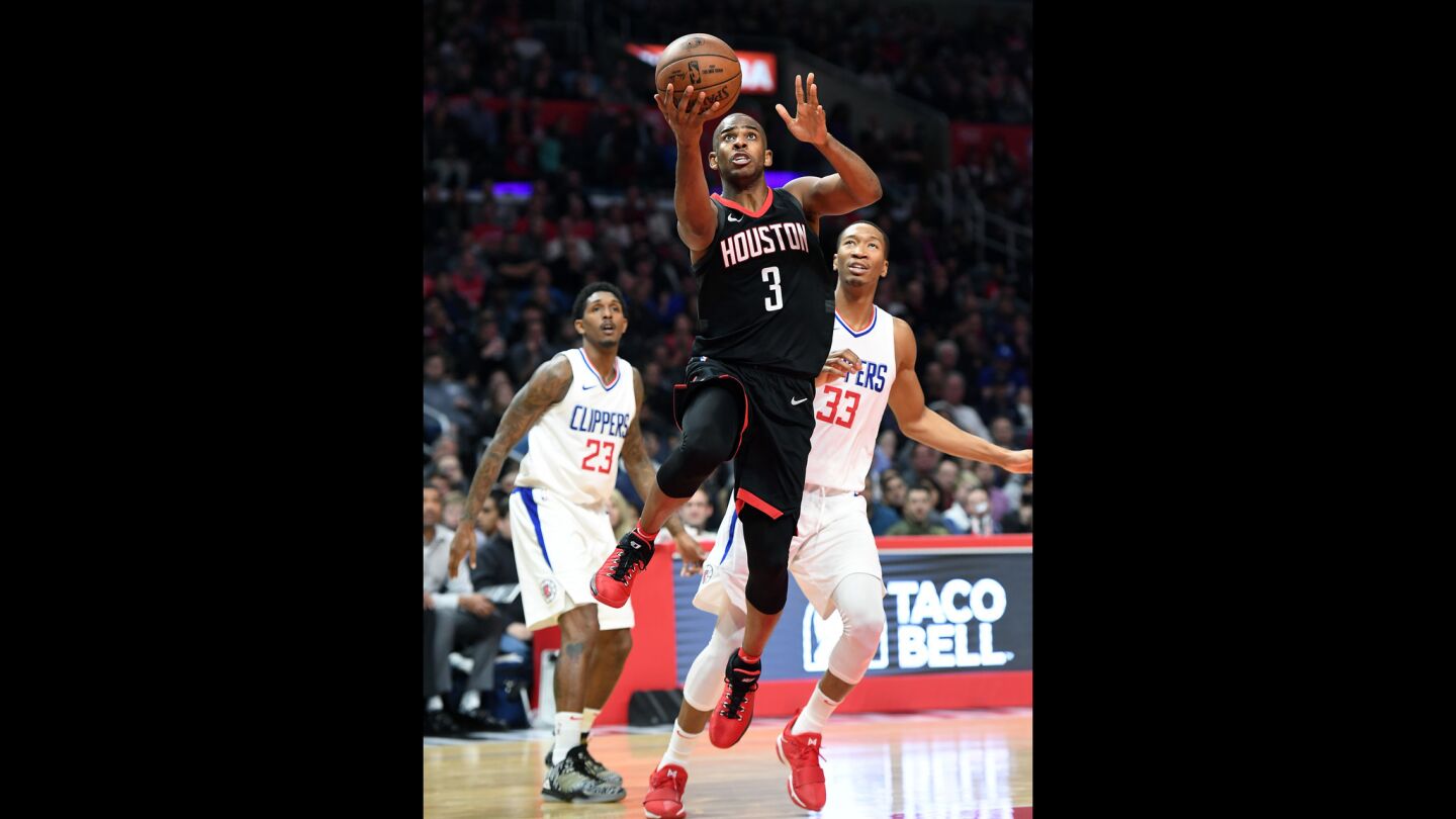 Houston Rockets' Chris Paul drives to the basket against Clippers Lou Williams, left, and Wesley Johnson in the fourth quarter.