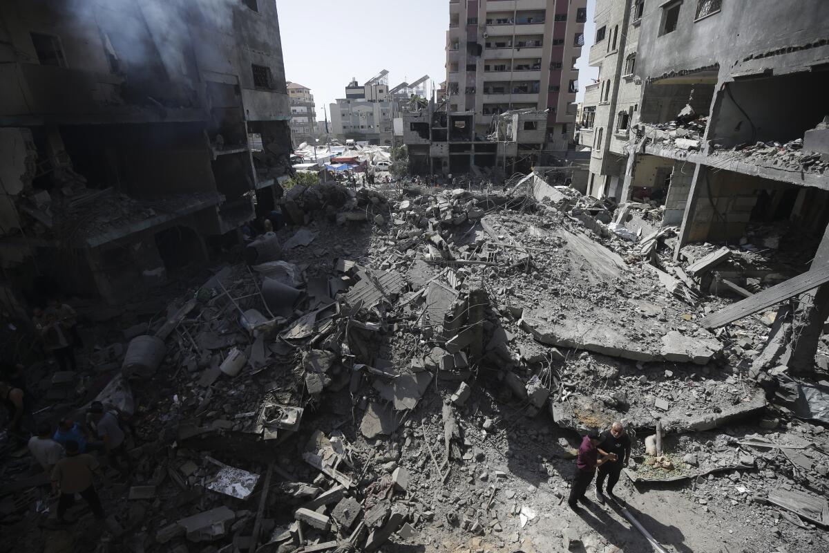 Palestinians look at the aftermath of the Israeli bombing in Nuseirat refugee camp, Gaza Strip.
