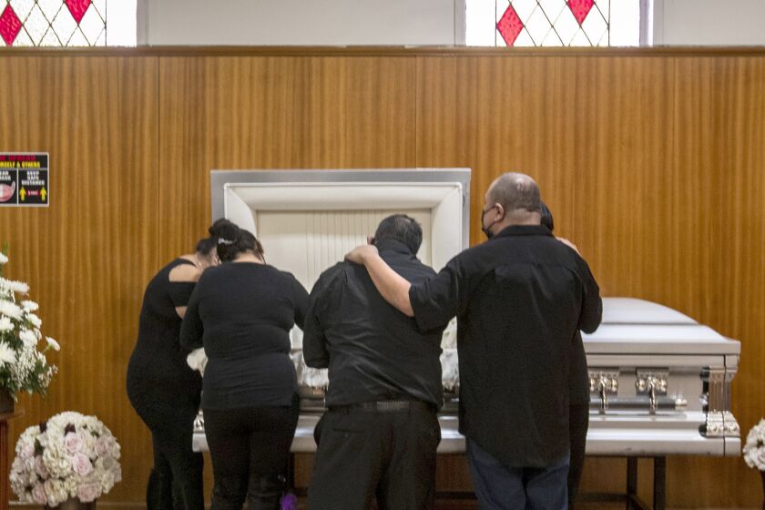 EAST LOS ANGELES, CA - DECEMBER 20: Family members gather to mourn Edith Fernandez alongside her casket at the Continental Funeral Home on Sunday, Dec. 20, 2020 in East Los Angeles, CA. The 47-year-old died Dec. 8, 2020 from complications of Covid-19. (Brian van der Brug / Los Angeles Times)